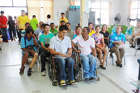 Disabled Chonburi residents listen as Ruangpit Kankulwot lectures on how to make flowers from gossamer and paper.